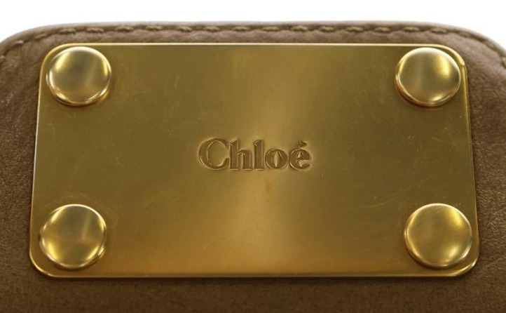 クロエのアイテムの金属プレート。ロゴ刻印の例を示している。