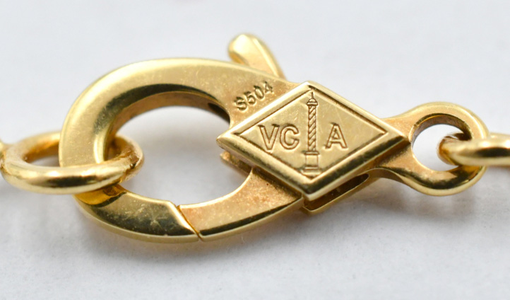 ヴァンクリ正規品のクラスプにあるVCAロゴと円柱の刻印。ひし形の中に標準サイズの精密な刻印が施されている。